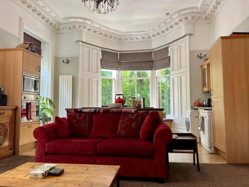 格拉斯哥Beautiful Double Room in Idyllic West End Townhouse的客厅设有红色的沙发和窗户。