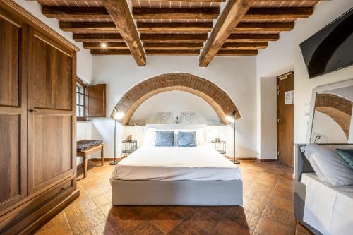 蒙特罗尼德阿尔比亚Hotel More di Cuna的一间带一张床铺的卧室,位于一个拱形的房间