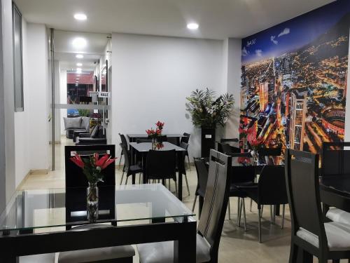波哥大拉德尔高级酒店的用餐室配有桌椅,墙上挂有绘画作品