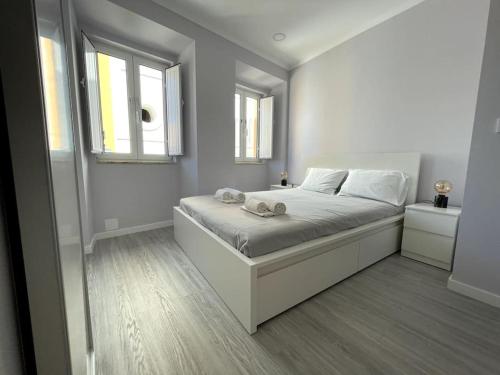 阿尔科谢蒂CASA ALCOCHETANA的一间白色卧室,配有床和2个窗户