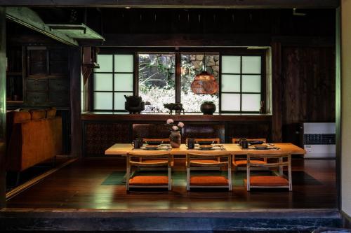 山梨市LiveGRACE House Lake Saiko 西湖古民家的一间带桌椅和窗户的用餐室