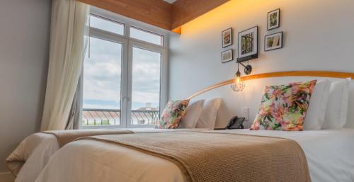 英雄港Hotel Monte Brasil的一间卧室设有一张大床和窗户