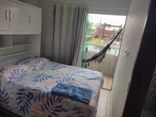 嘎林海斯港Studio A completo 400m da praia的一间卧室配有一张床,阳台设有窗户