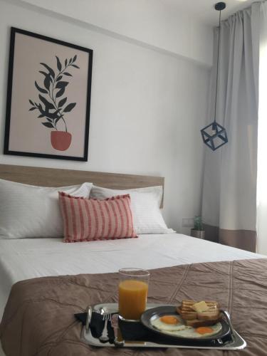 克拉法吉亚Blue View Suites的床上的食品和橙汁托盘