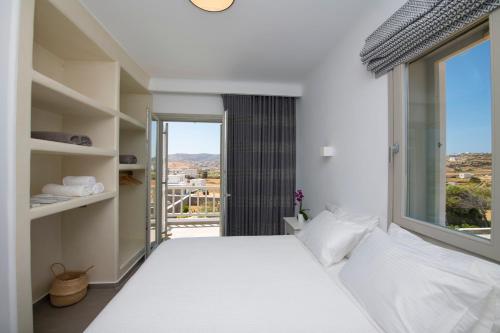 帕诺尔莫斯米科诺斯Summer Breeze Luxury Villa Mykonos的卧室设有一张白色大床和一扇窗户。