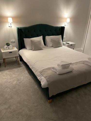 莱斯诺夫Royal Boutique的一间卧室配有一张大床和绿色床头板