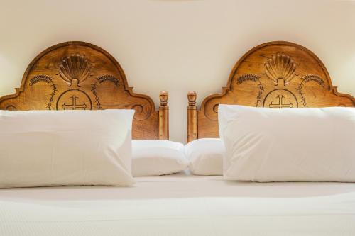 利亚内斯唐帕克酒店的一张带两个木制床头板和白色枕头的床