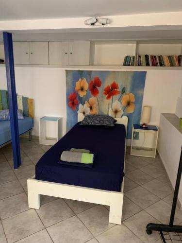 米蒂利尼studio in old town of Mytilene的一间卧室配有蓝色的床和一幅鲜花画