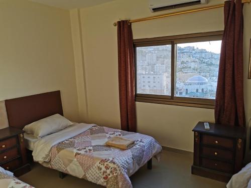 瓦迪穆萨佩特拉门大酒店 的一间卧室设有一张床和一个窗口