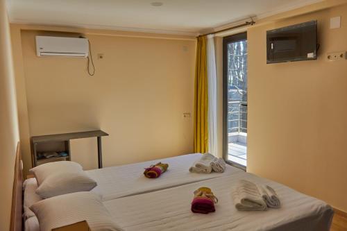 谢赫维蒂利Villa Story Hotel的一间卧室配有两张床、毛巾和窗户