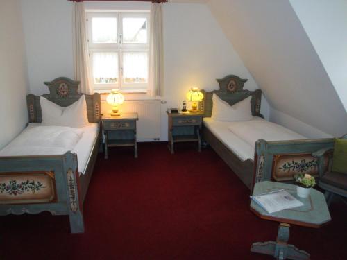 丁克尔斯比尔豪斯阿普尔伯格酒店的配有两张桌子和一扇窗户的客房内的两张床