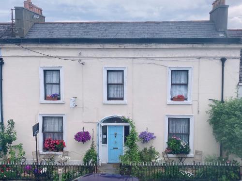 邓莱里Mulgrave Lodge的白色的房子,设有蓝色的门和窗户