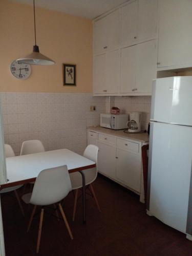 蒙得维的亚Aurora familiar的厨房配有桌子和白色冰箱。