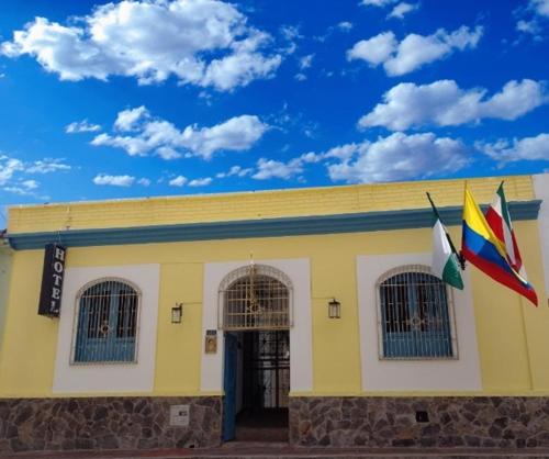 通哈Hotel Posada de Santa Elena的前面有两面旗帜的黄色建筑