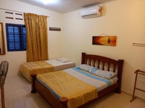珍南海滩THE COTTAGE LANGKAWI的一间卧室设有两张床和窗户。