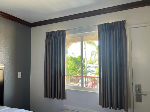 亨廷顿海滩亨廷顿海滩星光酒店的一间卧室设有蓝色窗帘的窗户