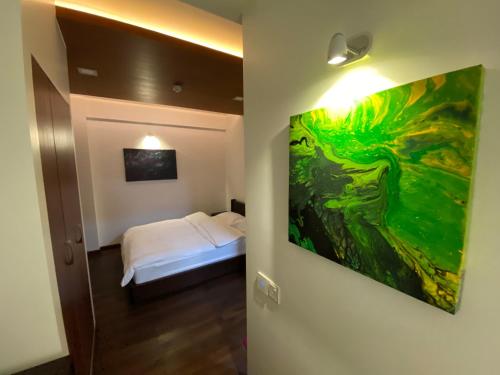 马累Luxury 3 Room Apartment by Oboe的一间设有一张床的客房,墙上挂着一幅画