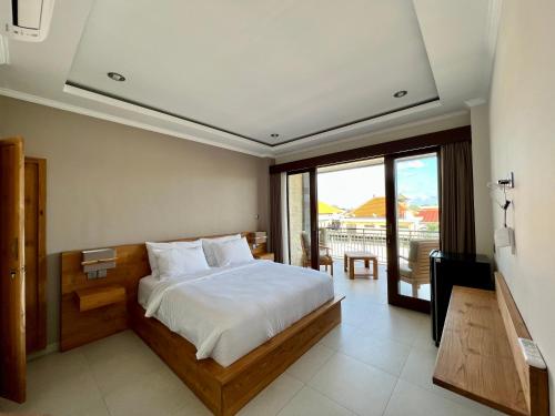 坎古Sandat Living的一间卧室配有一张床、一台电视和一个阳台
