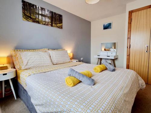 因弗内斯Modern 2 bedroom garden flat的一间卧室配有一张床,上面有两条毛巾
