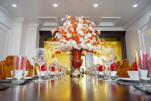 Châu CầuKhách sạn Hoa Đông的长桌子,带眼镜,花瓶