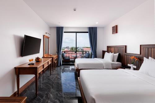 暹粒Two Seasons Siem Reap Hotel的酒店客房设有两张床和电视。