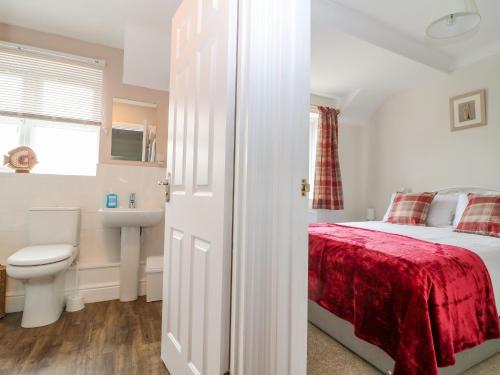 斯托昂泽沃尔德Woolpack Cottage的一间卧室配有床、水槽和卫生间
