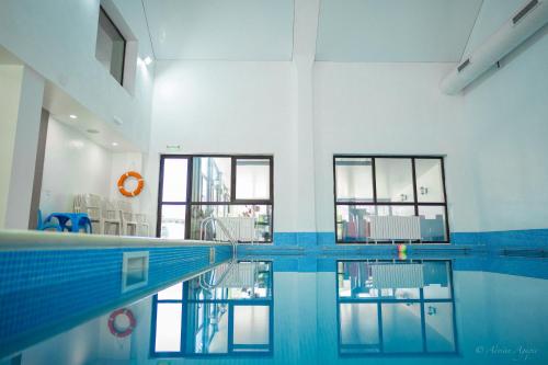 普雷代亚尔赫拉酒店的一座带窗户的建筑中的游泳池