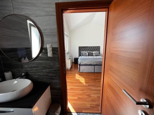 特罗吉尔Villa Sanja I的一间带水槽和镜子的浴室以及一张床