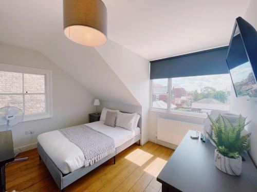 大雅茅斯Stunning 8-Bed House with Sea & Beach Views的一间卧室配有一张床、一张书桌和一个窗户。