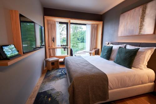 MutignyLOISIUM Wine & Spa Hotel Champagne的一间卧室设有一张大床和一个窗户。