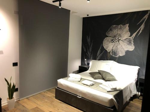 福贾IL TIGLIO VERDE的卧室配有一张挂有花卉画的床铺。