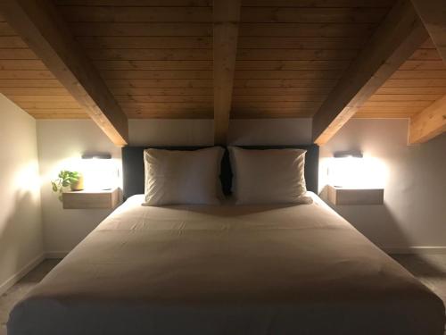 蒙特格罗索达斯提Sotto La Vigna Charm Stay Adults only vacation Appartement Hayloft的一张带两个枕头的床,房间有两个灯