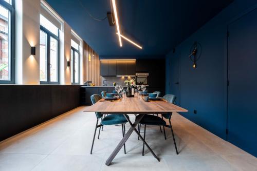 蒙斯Atypique LOFT Mons City Center的一间设有木桌和蓝色墙壁的用餐室