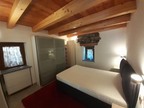 ChampdeprazAcero Rosso的一间带白色床铺的卧室,位于带木制天花板的客房内。