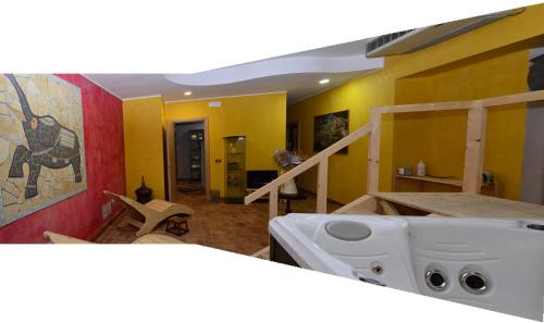 蒙蒂菲阿斯科尼阿尔塔维拉酒店的一间设有黄色墙壁和白色水槽的客房
