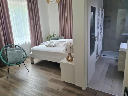 卢布尔雅那AZUR ROOMS LJUBLJANA的一间卧室配有一张床、一把椅子和一个浴缸