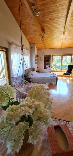 阿达兹Spacious house with indoor pool & sauna.的一间带秋千、一张床和鲜花的房间