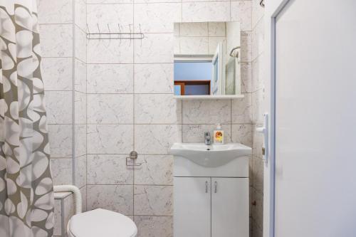哥鲁拜克Vila Peristeron的白色的浴室设有水槽和卫生间。
