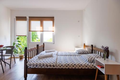 哥鲁拜克Vila Peristeron的一间卧室配有两张床和一张桌子及椅子