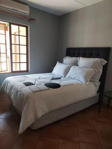 贝拉贝拉Pendleberry Holiday Resort - Unit 40的卧室配有一张带白色床单和枕头的大床。