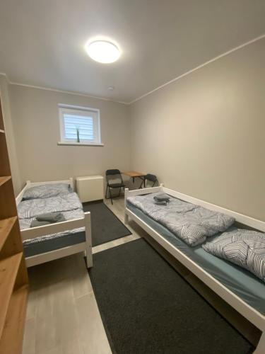 乔左维尔考普尔斯基Noclegi Pracownicze Parking Busy的客房设有两张床、一张桌子和一扇窗户。