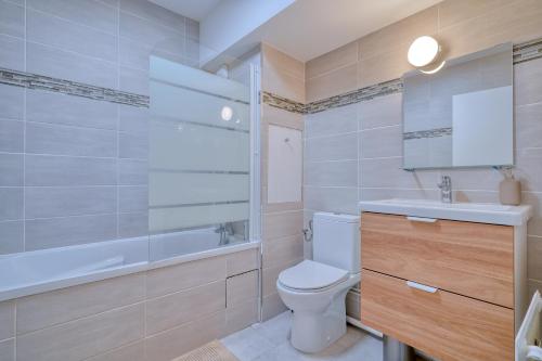 CourcouronnesLogement Elia的浴室配有卫生间、盥洗盆和浴缸。