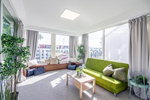 考纳斯The house Kaunas的客厅设有绿色沙发和大窗户