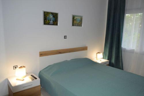 里托楚伦Litochoro apartment in Estate A1的一间卧室配有一张床和两个带灯的床头柜