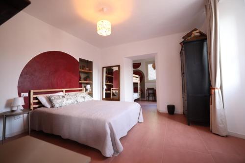 曼德洛德拉廖Il Mallo Verde - Lake Como B&B的一间卧室配有一张大床和红色床头板