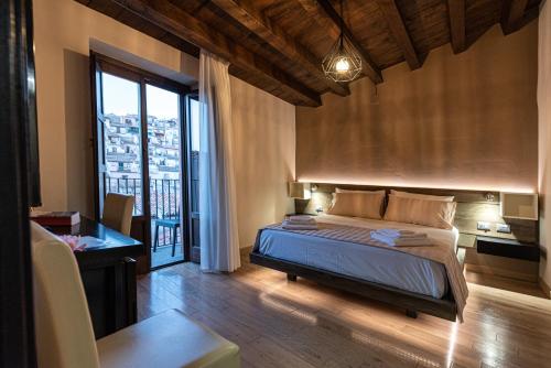 GratteriGratteri Resort的一间卧室配有一张床、一张书桌和一个窗户。