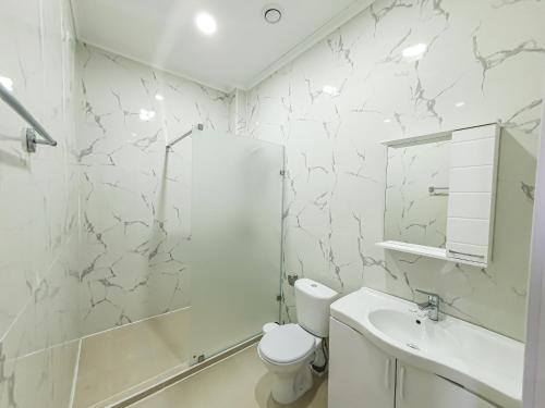 阿特劳Ritz Hotel的白色的浴室设有卫生间和水槽。