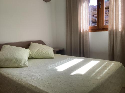 维琪奥港菲奥里迪圣朱利亚酒店的一间卧室配有一张床,窗户让阳光照耀