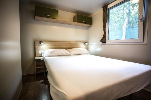 格拉多博斯克露营地的窗户客房内的一张大白色床