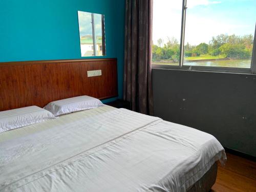 米里Super OYO 90579 U Inn的一间卧室配有一张蓝色墙壁和窗户的床
